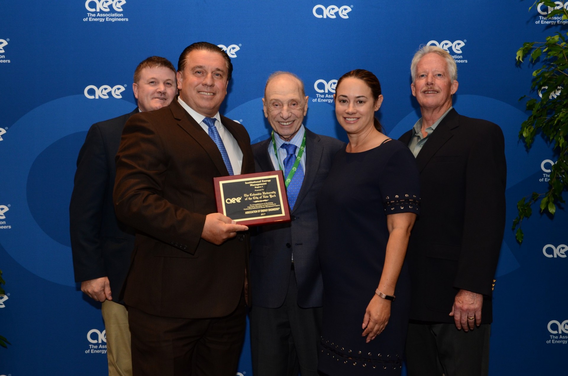  George Pecovic (left), AVP for Plant Engineering and Utilities Operations, and Jennifer Kearney (right), acting director of energy programs, receive the Institutional Energy Management award for the northeast region from officials of the Association of Energy Engineers at the 2017 World Energy Engineering Congress.