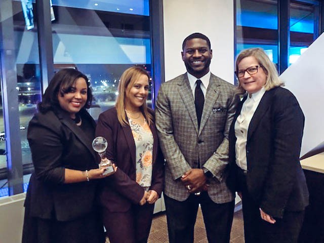 From left to right: Columbia Housing's Grace Urena, Maria Alba, and Joyce Jackson pose with their award and fellow award recipient, NFL Hall-Of-Famer LaDainian Tomlinson. Photo of the Housing team with their award